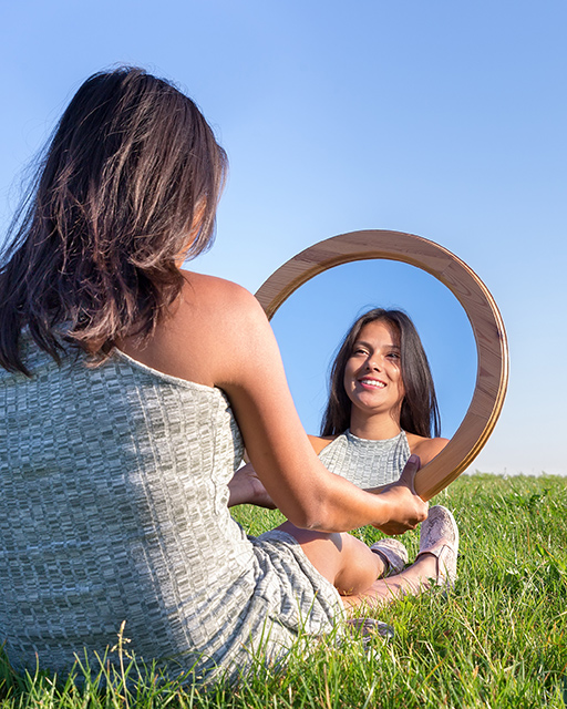 Woman looking in the mirror - Therapist for perfectionism and over achievers