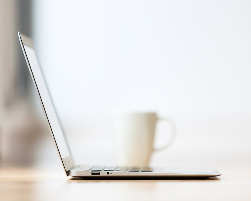 Laptop and cup of tea for teletherapy in New York