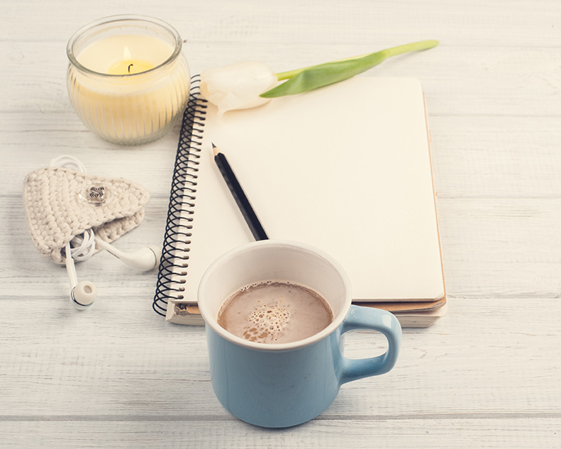 Notebook, coffee and ear pods for therapy with Lindsay